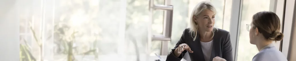 Persönlichkeitsentwicklung Seminar - Zwei Frauen unterhalten sich im Büro